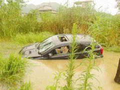 小轿车因车速过快 撞断四棵树后翻入水田(图)
